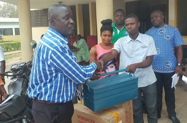 The DCE for Bibiani (left) presenting a set of equipment to Mr Atta Amos while Mr Ebenezer Mensah and others look on